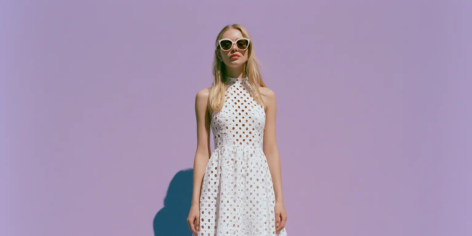 Frau im weißen Lochstickerei-Kleid mit deutlich sichtbarem Eyelet-Muster und weißer Sonnenbrille vor fliederfarbenem Hintergrund – KI-Illustration