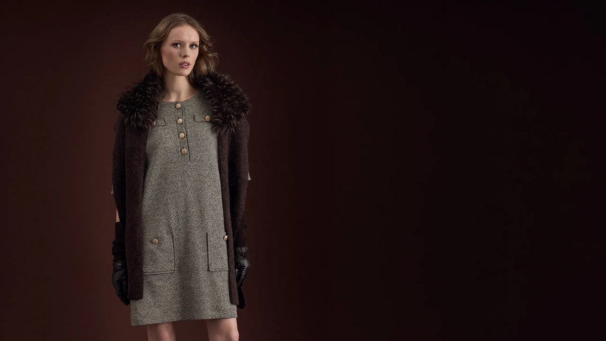 Model trägt Tweedkleid mit Zierknöpfen in Steingrau