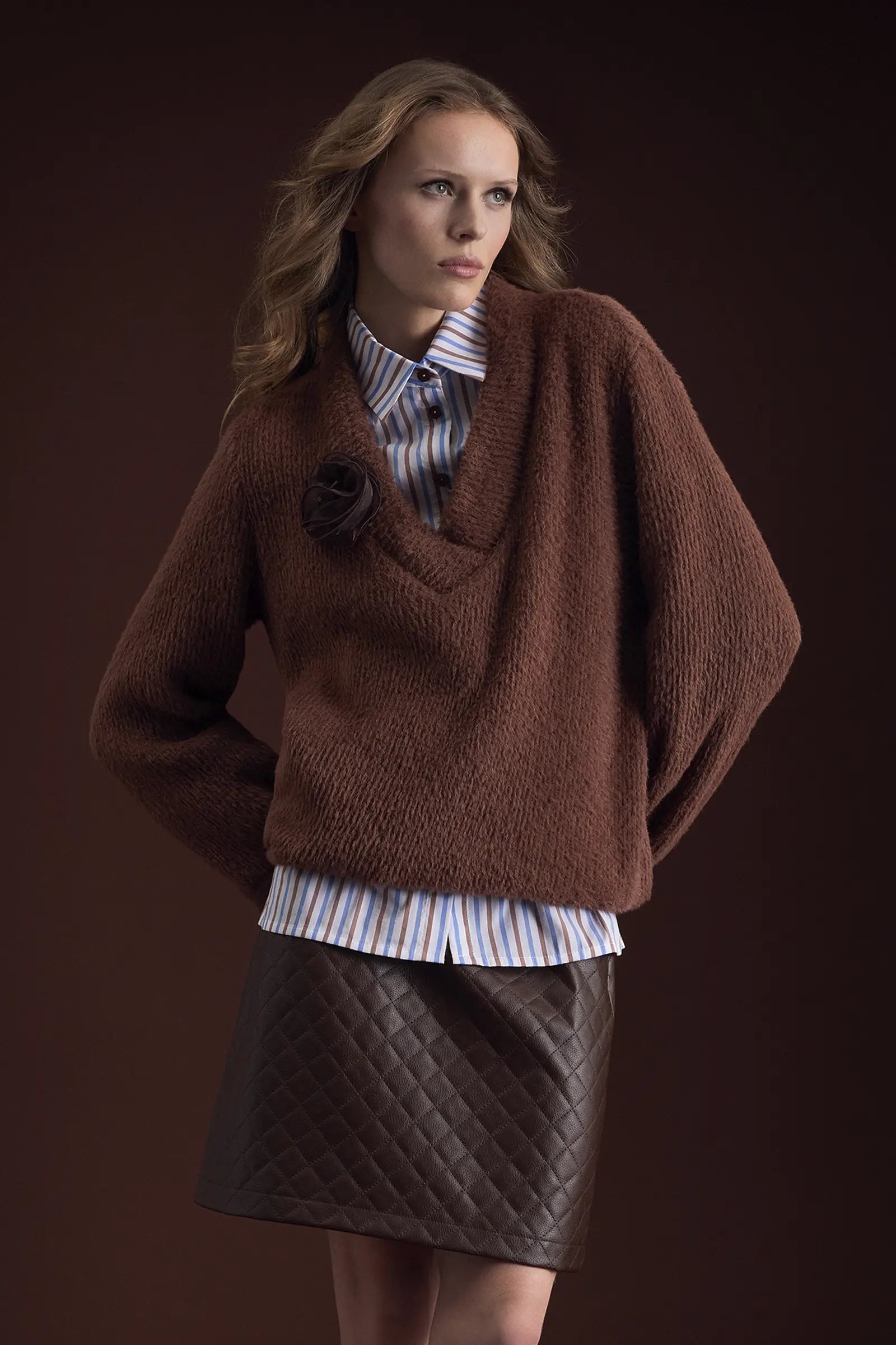 Bruine gebreide trui in cappuccino, gewatteerde rok in espresso en lichtblauwe streepblouse – Ana Alcazar herfst/winter 2026/2027